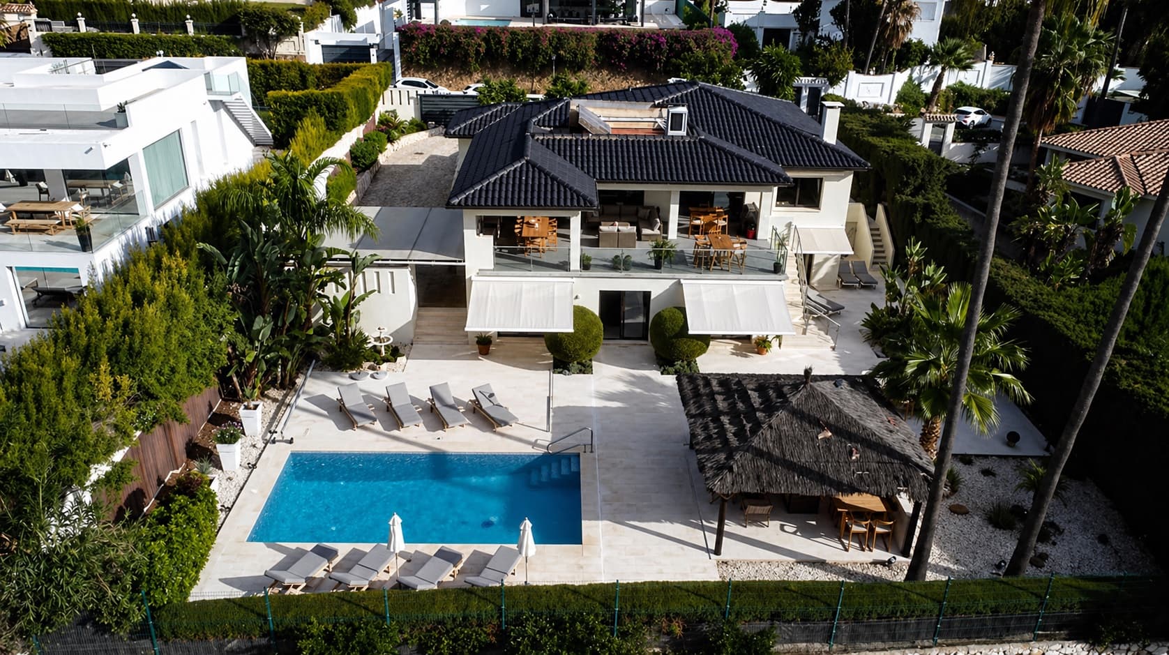 Villa Magna from above: terraces, pool and thatched cabana in the foreground